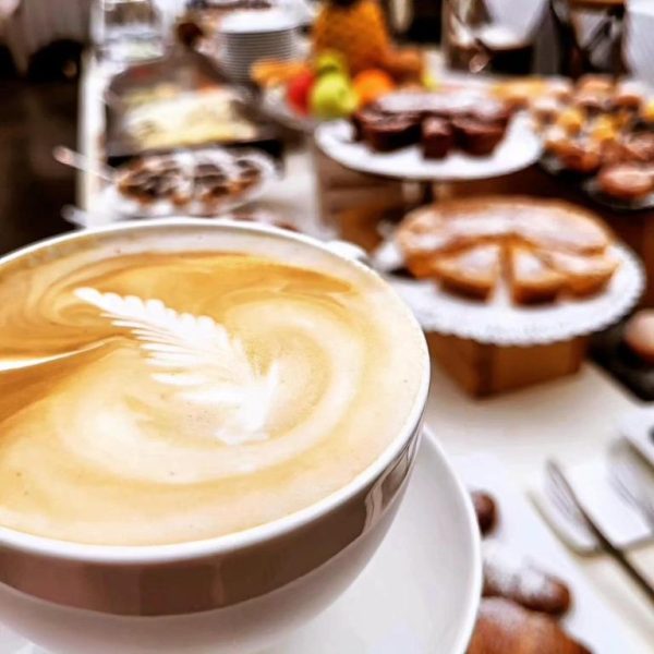 Café con arte latte y variado buffet de repostería en el desayuno del Cortona Resort & Spa