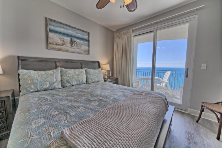 Habitación con cama doble y vistas al mar desde balcón en Ocean Front Condo con increíbles vistas