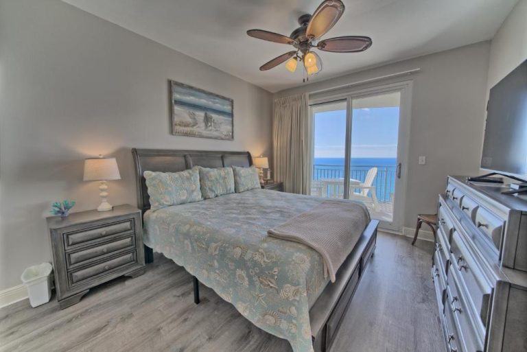 Habitación principal con cama doble y vistas panorámicas al mar en Ocean Front Condo con balcón