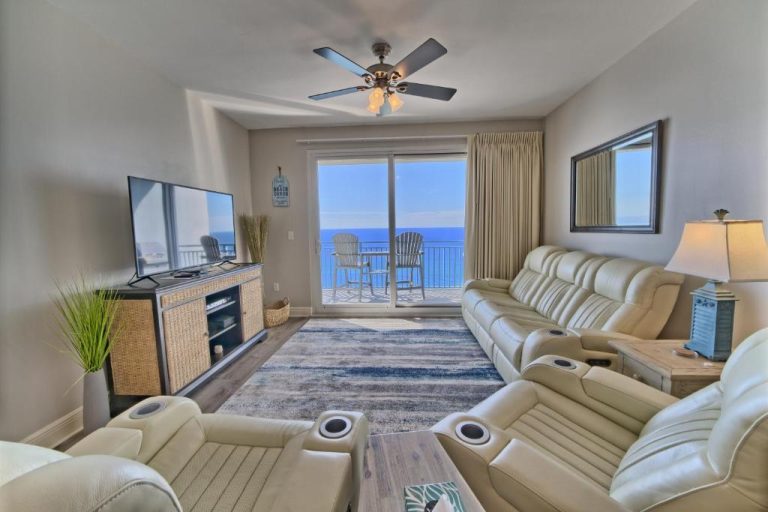 Sala de estar con sofás de cuero y vistas al mar desde balcón en Ocean Front Condo