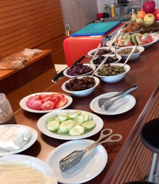Buffet de desayuno con aceitunas, pepino, tomate y frutas frescas en Kanakis Blue Beach Apartments