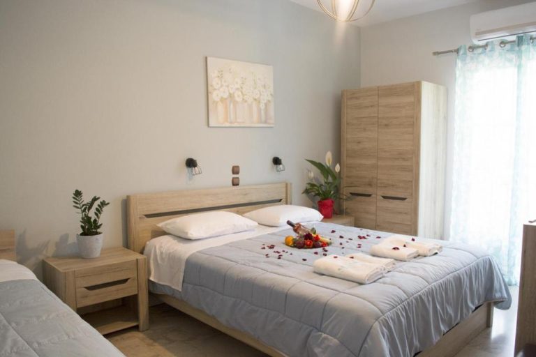 Habitación doble con cama matrimonial decorada con pétalos y frutas en Marina Apartments Agios Gordios Corfú