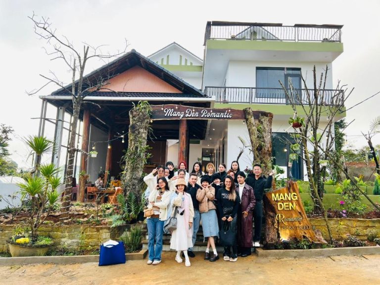 Grupo de visitantes posando frente a la fachada del hotel Mang Den Romantic en Vietnam