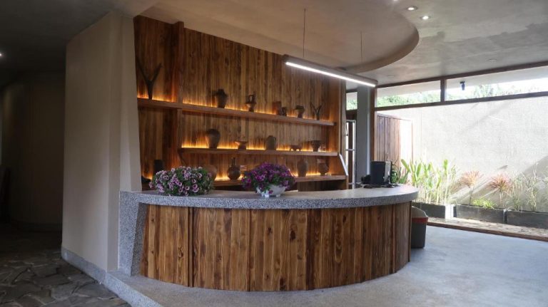 Recepción circular de madera con decoración artesanal y flores en MăngDiang Boutique Hotel
