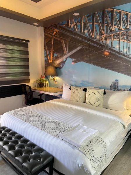Habitación doble con mural del Puente de Sídney en Italy Condotel Darasa, cama king y escritorio