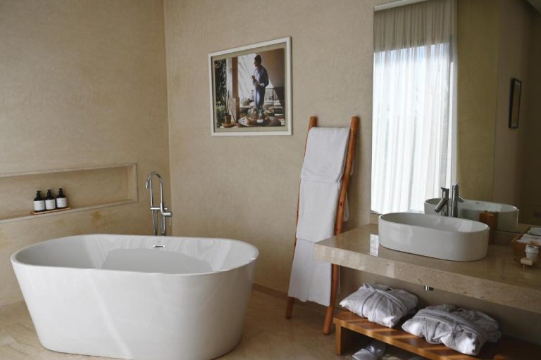 Baño de suite con bañera exenta independiente y lavabo de diseño en Maison Kenoosha Boutique Hotel & Spa