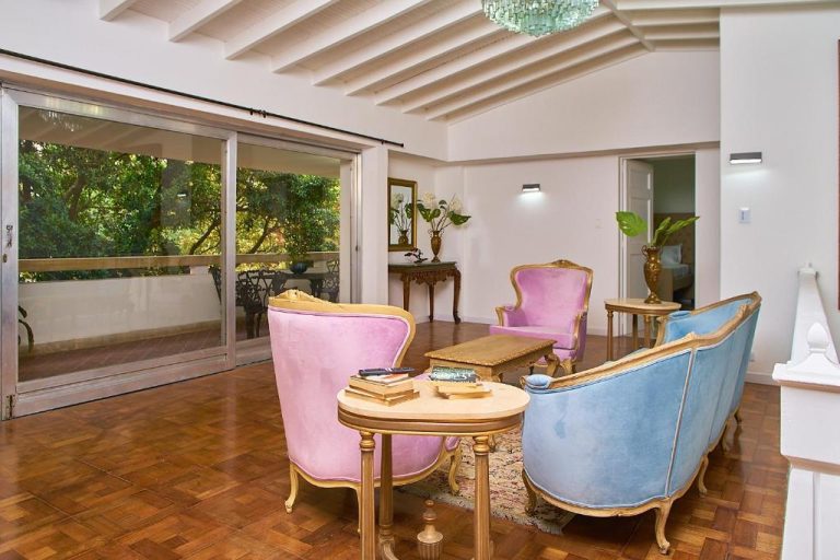 Elegante sala de estar con sillones clásicos rosas y azules en Hotel Boutique Fiorentina Medellín