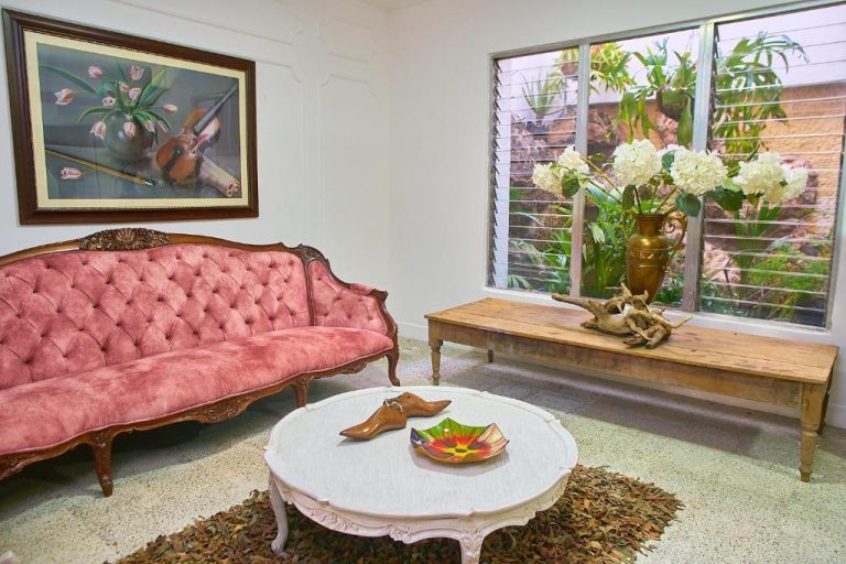 Sala vintage con sofá rosa tufted y decoración clásica en Hotel Boutique Fiorentina Medellín