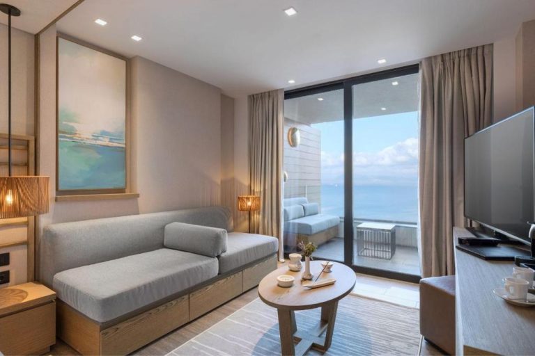 Habitación con sofá, salón y terraza con vistas al mar en Angsana Corfu Resort & Spa