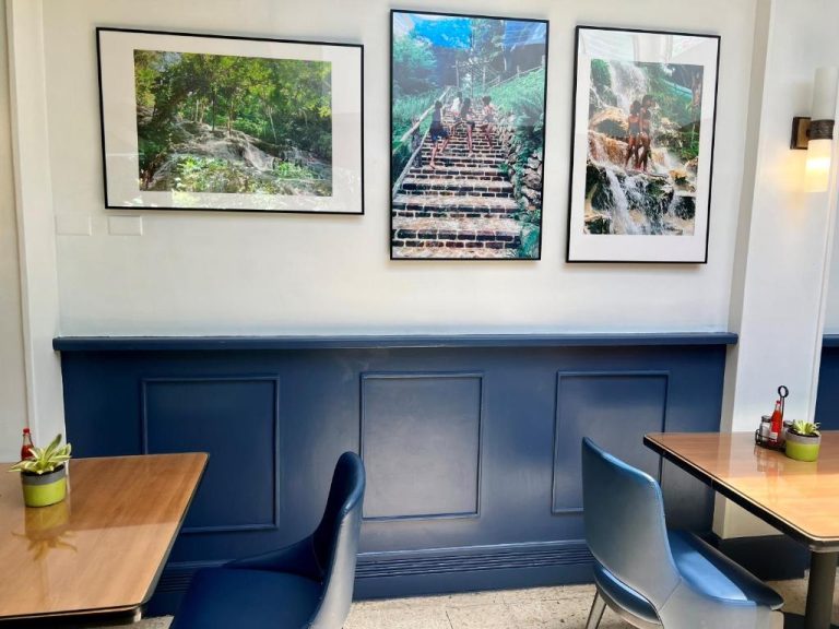 Comedor interior del Deja Resort All Inclusive con arte tropical en paredes y mobiliario azul moderno