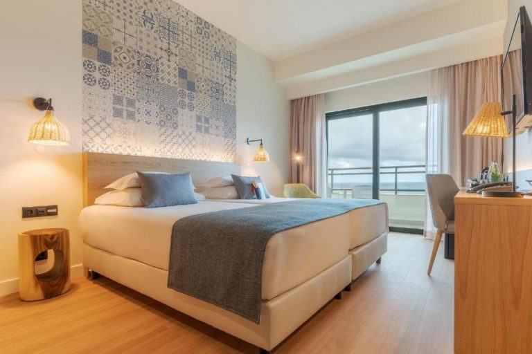 Habitación doble con cama king y vistas al mar en el hotel Sentido Galosol, decoración azul y madera