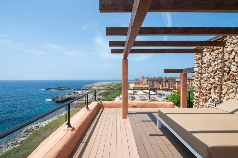 Terraza con pérgola de madera y vistas al mar mediterráneo en Hotel Menorca Binibeca by Pierre & Vacances