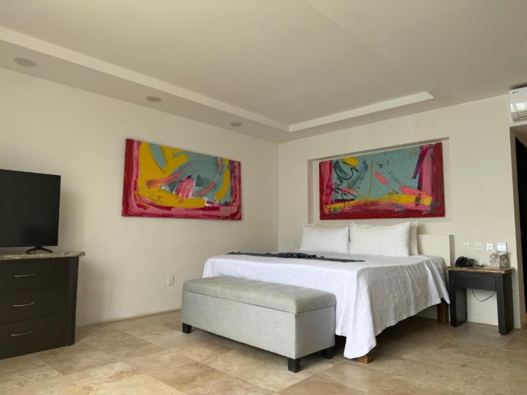 Habitación king size con arte abstracto colorido en Delfin Beachfront Resort Puerto Vallarta