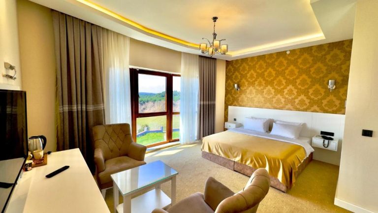 Habitación doble de lujo con cama king y decoración dorada en Green Roof Boutique Hotel & SPA Istanbul Airport