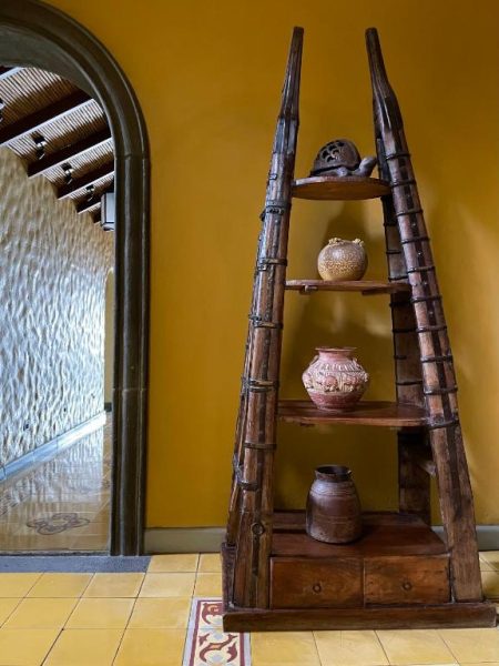 Estantería artesanal de bambú con vasijas de cerámica decorativas en el Hotel 1915 Inn & Suites