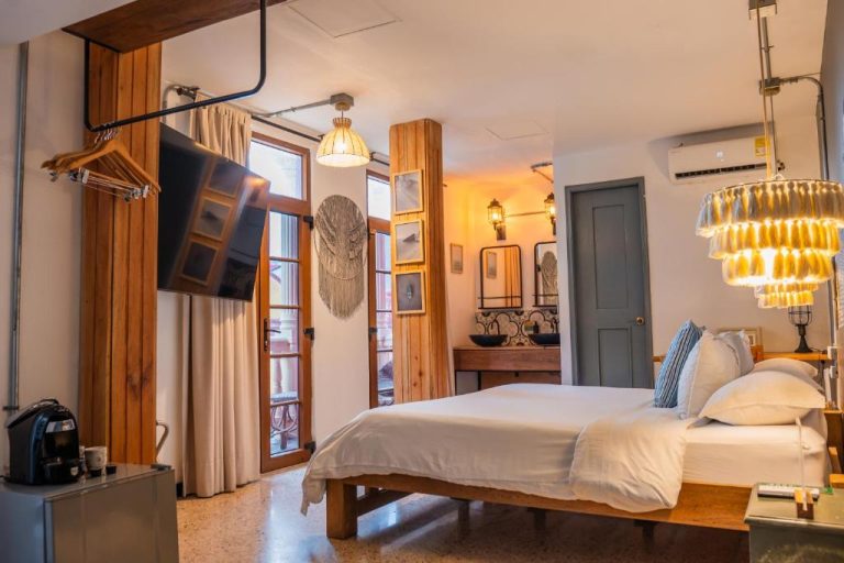 Habitación doble con cama king, decoración moderna y lámpara de cristal en Hotel Kim