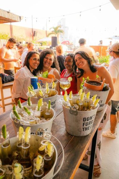 Grupo de amigas disfrutando de cócteles en la terraza del Hotel Kim durante una animada fiesta al aire libre