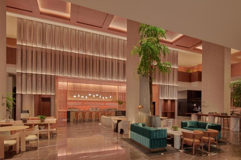 Elegante lobby bar y zona lounge con sofás de terciopelo verde del hotel Amara Singapore