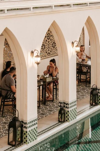 Terraza del restaurante con piscina y arcos blancos de estilo árabe en Layla Tulum Adults Only