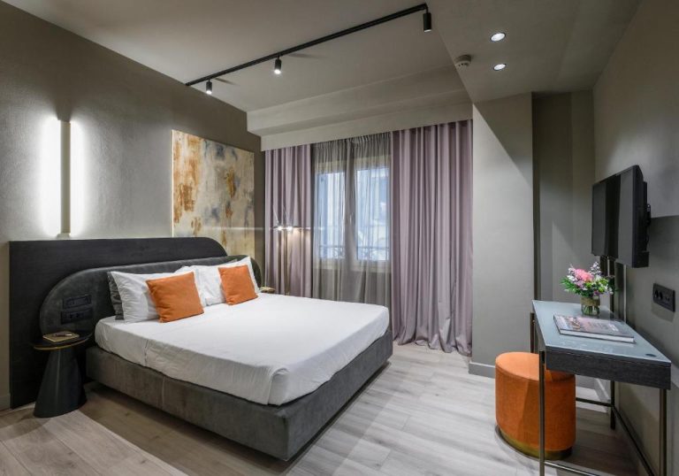 Habitación doble de diseño moderno con cama king y decoración en tonos grises del Arcadion Hotel