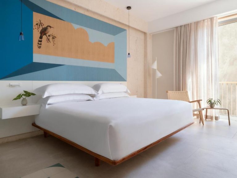 Habitación king con mural artístico azul y madera en Kimpton Las Mercedes by IHG