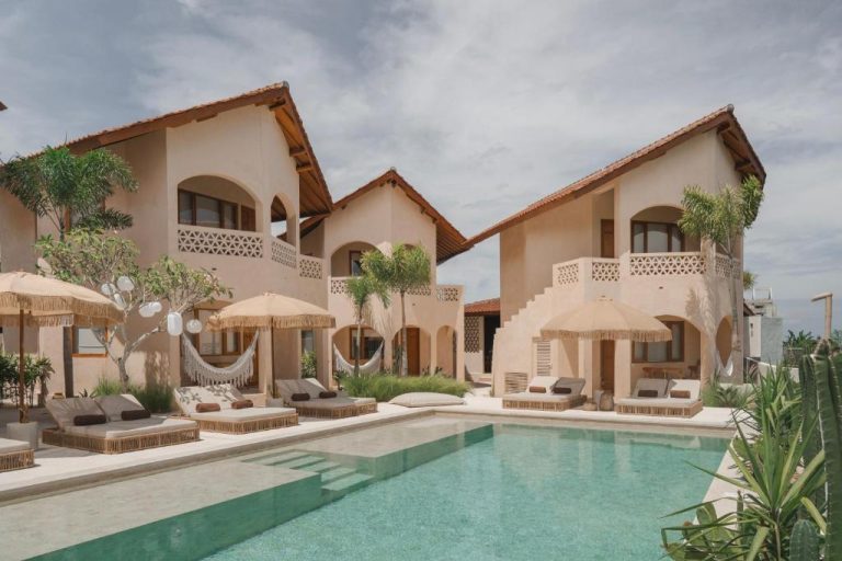 Piscina exterior con tumbonas y hamacas frente a las villas del Hotel Dune Seseh en Bali