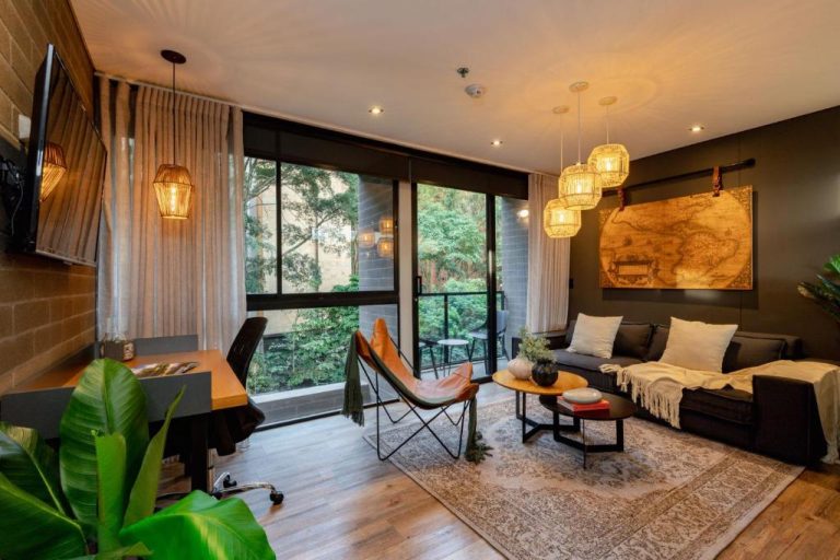 Sala de estar moderna con terraza y jardín en Loma Verde Aparthotel, decoración tropical y acogedora
