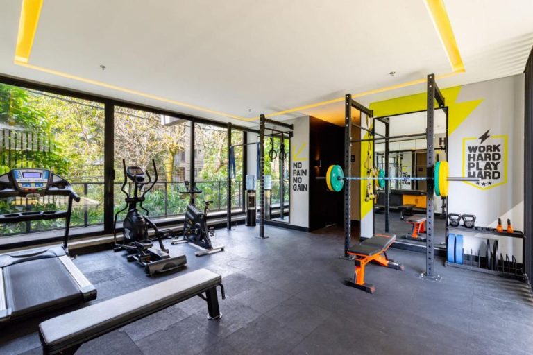Gimnasio moderno con máquinas cardio y zona de pesas en Loma Verde Aparthotel