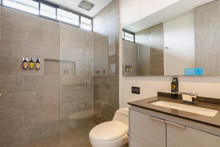 Baño moderno con ducha de lluvia y encimera de mármol en Loma Verde Aparthotel