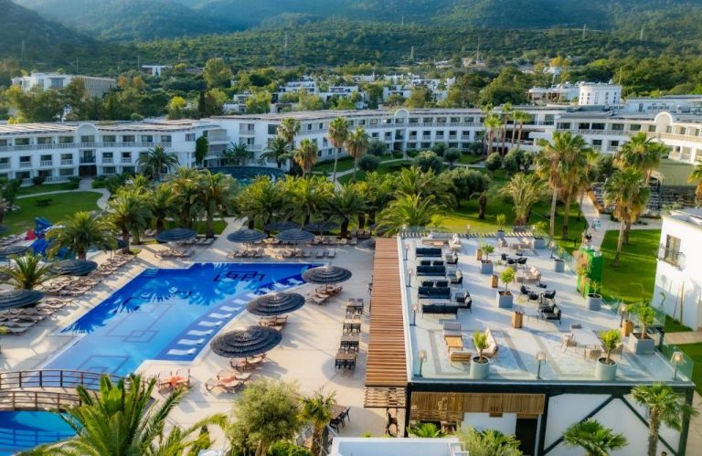 Vista aérea de la piscina exterior con tumbonas y palmeras del Samara Hotel Bodrum Ultra All Inclusive