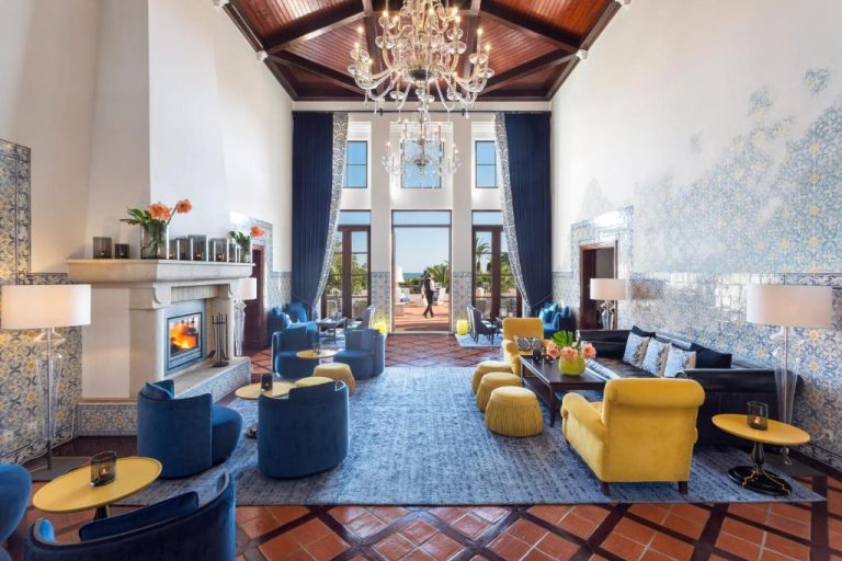 Elegante salón lobby del Vila Vita Parc con azulejos portugueses, chimenea y lujosa decoración en azul y dorado