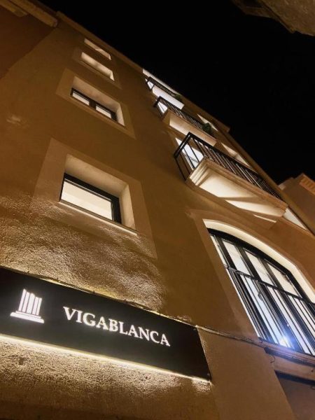 Fachada exterior nocturna de Vigablanca Apartments con iluminación elegante y balcones