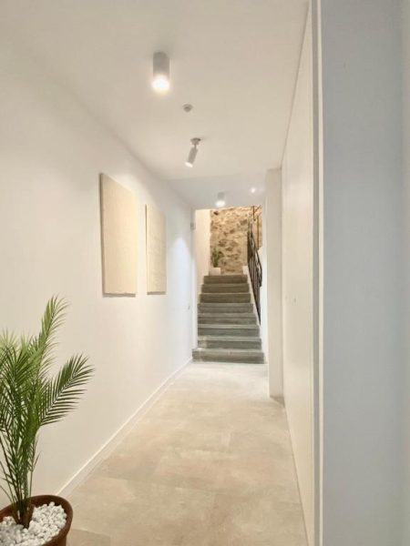Pasillo interior luminoso con escaleras y decoración minimalista en Vigablanca Apartments