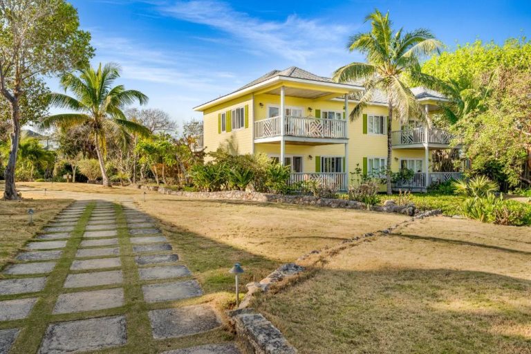 Fachada exterior del Pineapple Fields con jardín tropical y palmeras en las Bahamas