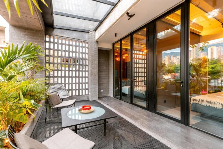 Terraza privada con jardín y sala exterior en Primavera Luxury Apartments Medellín con vistas a la ciudad