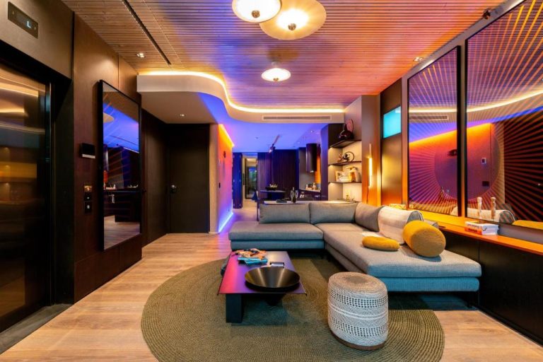 Sala de estar moderna con iluminación LED multicolor en Primavera Luxury Apartments Medellín