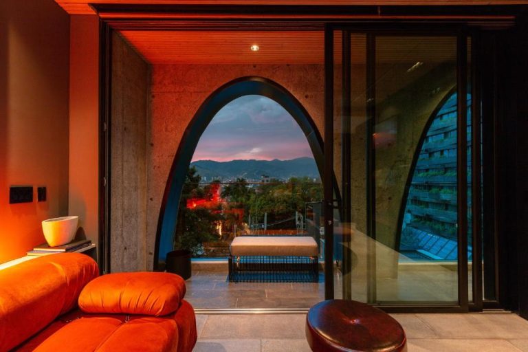 Suite de lujo con terraza y arcos de concreto con vista panorámica a la ciudad en Primavera Luxury Apartments Medellín