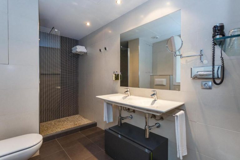 Baño moderno con doble lavabo y ducha de obra en el hotel ARTIEM Audax Adults Only