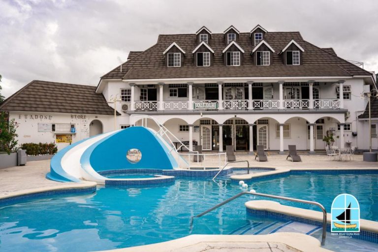 Piscina exterior con tobogán acuático y edificio principal del Ninth River Ocho Rios en Jamaica