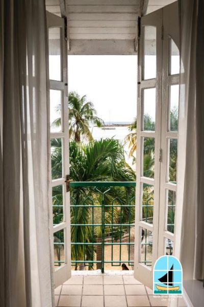 Balcón con puertas francesas y vistas al mar tropical en el hotel Ninth River Ocho Rios, Jamaica