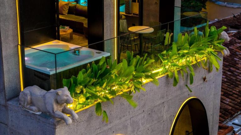 Terraza con jacuzzi iluminado y esculturas decorativas en Primavera Luxury Apartments Medellín