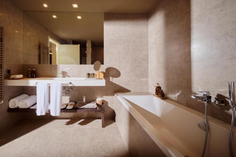 Baño de lujo con bañera encastrada y lavabo doble en Can Alomar Hotel
