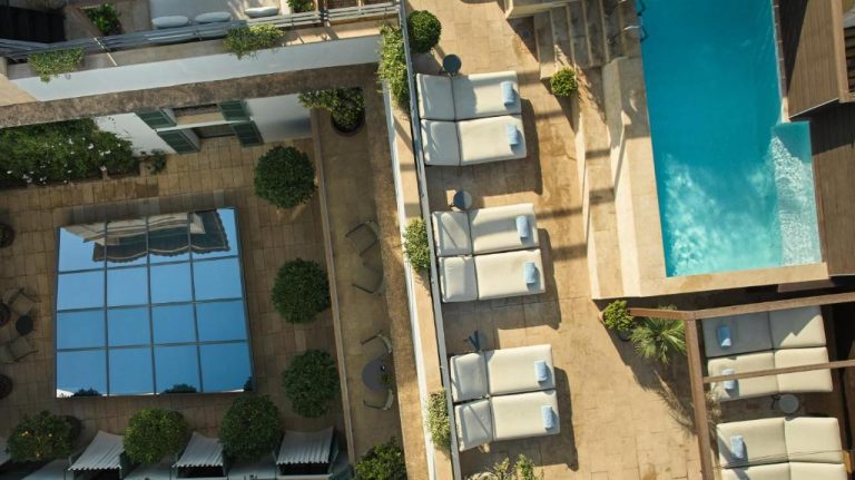 Vista aérea de la piscina exterior y terraza con tumbonas del Can Alomar Hotel
