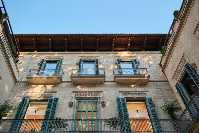 Fachada histórica del Can Alomar Hotel con balcones de hierro forjado y tienda Louis Vuitton en Palma