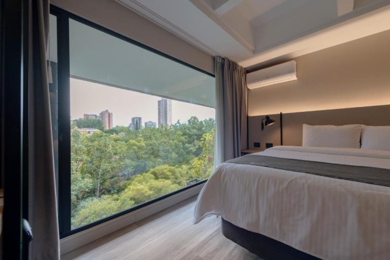Habitación doble con cama king y amplia ventana con vista al bosque urbano en Lettera Hotel