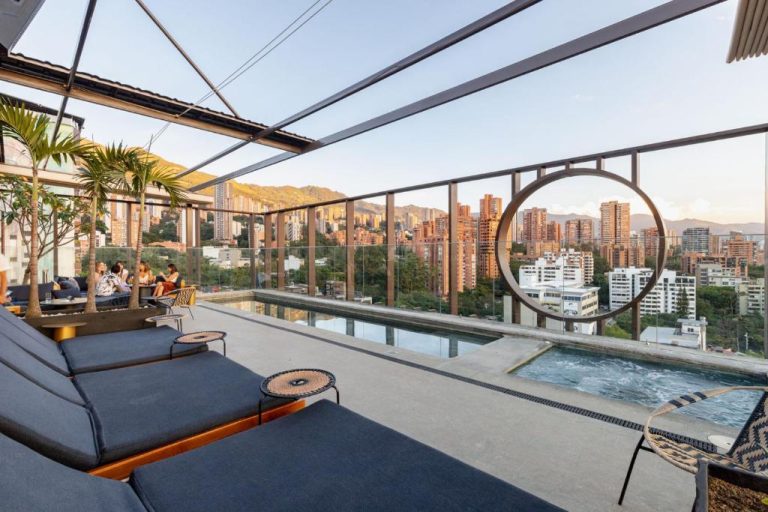 Terraza rooftop con piscina y tumbonas del Hotel Marquee Medellín con vistas al skyline de la ciudad