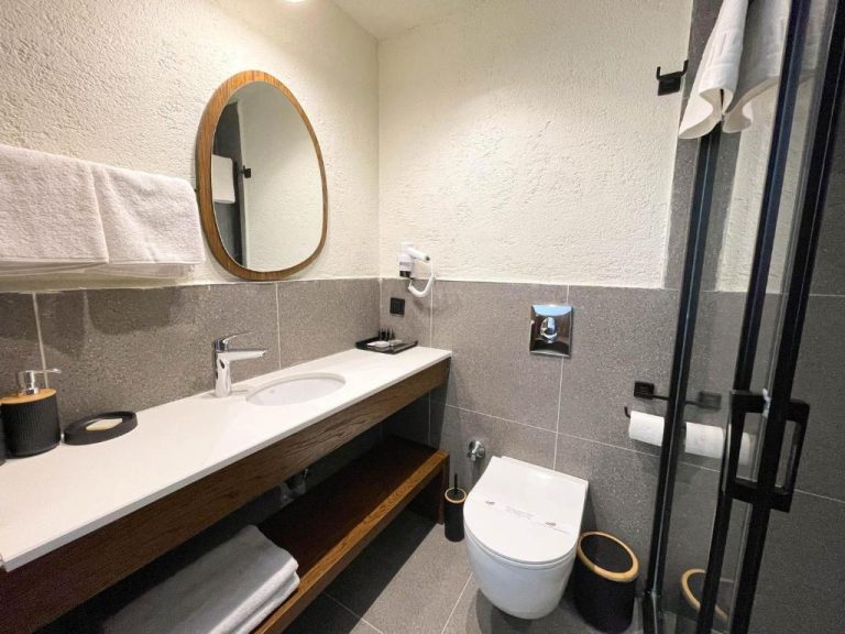 Baño moderno con ducha de cristal y lavabo empotrado en el Now Boutique Hotel