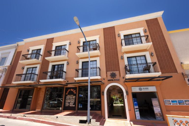 Fachada exterior del Hotel Colli con balcones coloniales y tiendas en planta baja
