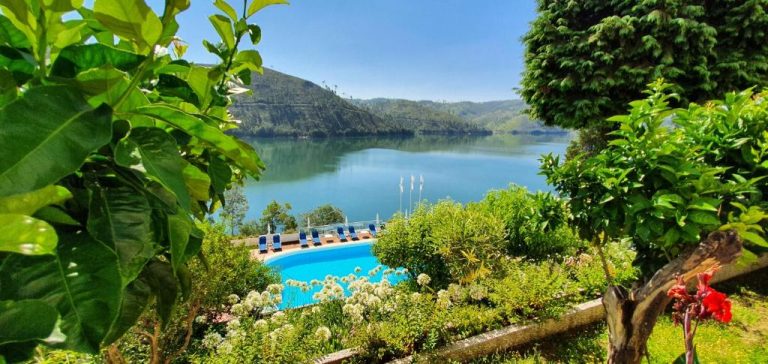 Piscina exterior con tumbonas y vista panorámica al lago en Lago Azul Eco Hotel rodeado de naturaleza