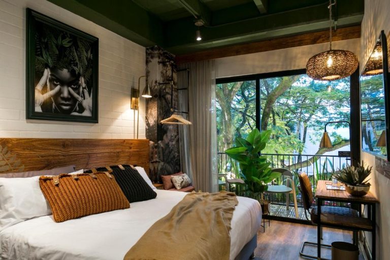 Habitación doble con decoración tropical y balcón con vistas al jardín en Celestino Boutique Hotel & Spa